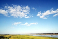 蓝天白云草地蓝天下的绿水河水图片